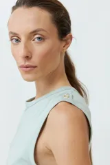 Musculosa roja de algodón con cuello redondo y botones decorativos en los hombros.