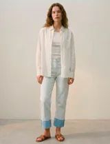 Jean de algodón de tiro medio, color celeste muy claro, con un dobladillo ancho y contrastante en color azul claro en los tobillos. El corte es recto o ligeramente holgado.