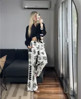 Pantalón palazzo blanco con estampado de motivos tribales en negro, cintura elástica y bolsillos laterales. Talle único.