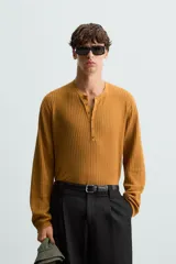 Camiseta de punto color marrón con cuello redondo y cierre frontal de botones.