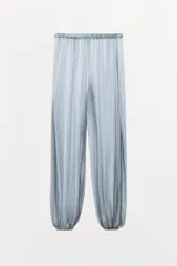 Pantalón celeste semitransparente de tiro medio con cintura elástica y tobillos abullonados con elástico.