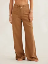 Pantalón de tiro medio alto color marrón, de corte ancho, con bolsillos delanteros y traseros.