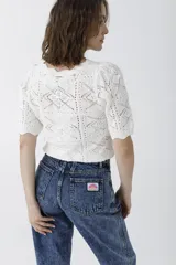 Pantalón de jean azul de tiro alto, corte recto y lavado claro con efecto nevado. Presenta pinzas en la cintura y bolsillos delanteros y traseros.