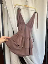 Minivestido negro con escote halter y falda con volados.