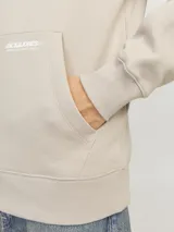 Canguro color beige con capucha, cordones ajustables, mangas largas con costura set-in y bolsillo tipo canguro. Estampado con el logo de la marca en el pecho.
