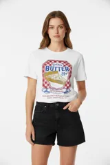 Remera blanca de algodón con estampado frontal de un logo con forma de etiqueta de manteca.