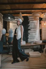 Chaleco negro de vestir, con escote en V y cierre frontal de botones dorados.