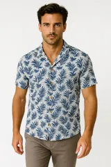 Camisa de viscosa con estampado de hojas de palmera en tonos azul y blanco, con cuello clásico y manga corta.