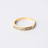 Anillo dorado en oro 18k con hilera de circonias blancas engarzadas.