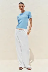 Remera blanca de punto con cuello redondo y mangas cortas con ribete negro en cuello, mangas y ruedo.