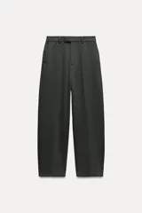 Pantalón de tiro medio color verde oscuro, confeccionado en hilatura con viscosa. Cintura con trabillas, bolsillos delanteros, pierna ancha y cierre frontal con cremallera, botón y gancho metálico.