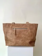 Cartera tipo tote de cuero graneado color negro, con textura uniforme y suave al tacto. Tiene manijas de 55 cm, bolsillo frontal con broche imantado, bolsillo trasero con cierre metálico, cierre principal metálico, forro interior y tres bolsillos internos (uno con cierre, uno plaqué y uno tipo sobre con solapa y botón).