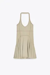 Vestido corto color beige con cuello halter y falda con godets.