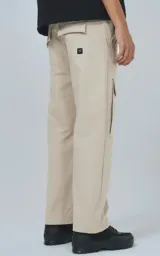 Pantalón cargo beige de corte recto con bolsillos laterales y etiqueta con logo en la pierna.