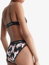 Bombacha bikini de algodón con estampado floral en tonos blanco y rojo sobre fondo negro. Cintura elástica con logo de Calvin Klein.