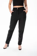 Conjunto negro de top corto con breteles anchos y pantalón de vestir de tiro alto con botón dorado.