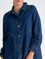 Vestido camisero de denim azul oscuro, marca Elan. Tiene cuello con solapa, abertura central con botones metálicos dorados, bolsillos laterales, mangas largas con puño elastizado, largo mini y calce holgado.