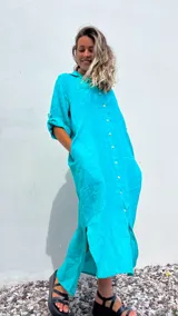 Vestido camisero largo color verde agua, confeccionado en lino 100%, con cuello camisero, abotonadura frontal completa, mangas 3/4 con trabilla y bolsillos laterales.