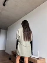 Blazer verde con rayas verticales blancas, de corte holgado, con cuello clásico, cierre frontal con botones y mangas largas.