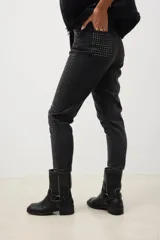 Pantalón de jean negro con corte skinny y tachas plateadas.
