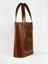 Matera de cuero color marrón con bolsillo exterior con textura de piel de cocodrilo. Interior forrado con compartimento para el mate y bolsillo de cuero.