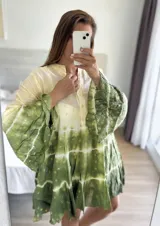 Vestido corto con estampado batik en tonos verde y amarillo, con mangas largas acampanadas y cuello mao.