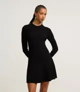 Vestido corto negro de punto con cuello polo, manga larga y botones en el escote.