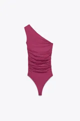 Body fucsia de poliamida con escote asimétrico, un solo tirante con pieza metálica dorada y frunces laterales.