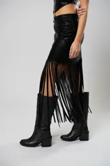 Falda midi de cuerina negra con flecos y abertura lateral.