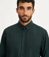 Camisa blanca de algodón, manga larga con botonadura frontal y cuello camisero.