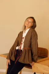 Chaqueta marrón de lana con forro de algodón y tiras de cuero. Diseño con cuello en V y corte a la cintura.