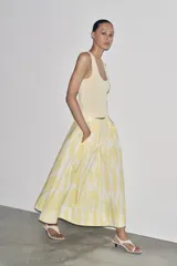 Falda midi de tiro alto confeccionada en hilatura de algodón con estampado geométrico en tonos rosa, marrón y bordó. Detalle de pliegues en cintura y bajo evasé. Cierre con cremallera oculta en costura.