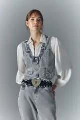 Chaleco vintage de denim rígido color gris, con botones metálicos grabados, bolsillos con solapa en el frente y tira de ajuste en la espalda.