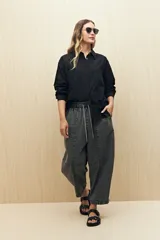 Camisa celeste de manga larga con cuello camisero y botones de nácar. Presenta detalles de broderie calado en el canesú y las mangas.