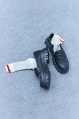 Mocasín blanco con diseño moderno, confeccionado en cuero vegano y goma.
