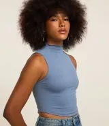 Blusa color beige, sin mangas, con cuello alto y confeccionada en tejido de poliamida seamless.