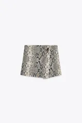 Falda pantalón de tiro alto con estampado animal print, cierre lateral oculto y aplique metálico en la parte delantera.