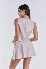 Short pollera plisada color beige con cierre trasero.