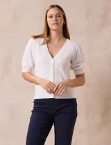 Cárdigan tejido color blanco, marca Tahari. Escote en V, manga corta abullonada con puño y abertura central con botones.