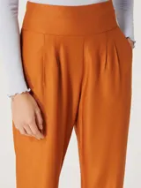 Pantalón de vestir color naranja, de corte recto y tiro alto, con pinzas en la cintura.