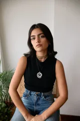 Collar con dije plateado en forma de espiral y cordón negro encerado.