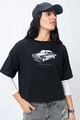 Remera cropped blanca de mangas ranglan con estampa frontal de un auto antiguo y texto "Vintage Gems / retro car club".