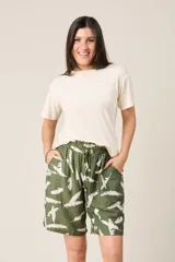Bermuda de tiro alto con elástico fruncido en la cintura y bolsillos laterales. El tejido es verde oliva con un estampado de plumas blancas.