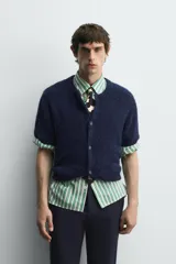 Cárdigan azul marino de manga corta tejido en hilatura con lana y alpaca, de textura suave. Tiene cuello redondo, rib en los bordes y cierre frontal con botones. Edición especial Harry Lambert for Zara x Disney.