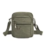 Morral bandolera de tela canvas color verde oliva, con correa regulable. Tiene cierre superior, dos bolsillos frontales con cierre, bolsillos internos y bolsillo trasero con cierre.
