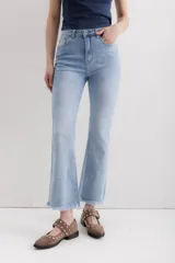 Pantalón de jean celeste de corte cropped flare, tiro alto y terminación desflecada.