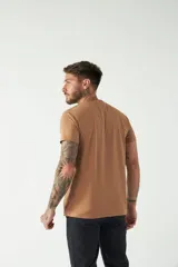 Remera básica color marrón claro, de corte regular, manga corta, cuello redondo y logo bordado en el pecho.