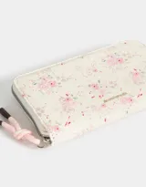 Billetera negra de cuerina con cierre y puller del mismo material. Tiene tag en relieve y monedero interno con cierre.