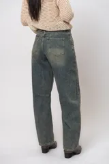 Pantalón de jean de tiro medio con pierna ancha y lavado gastado.