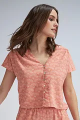 Blusa salmón con estampado de abanicos en color crudo, escote en V y cierre frontal con botones.
